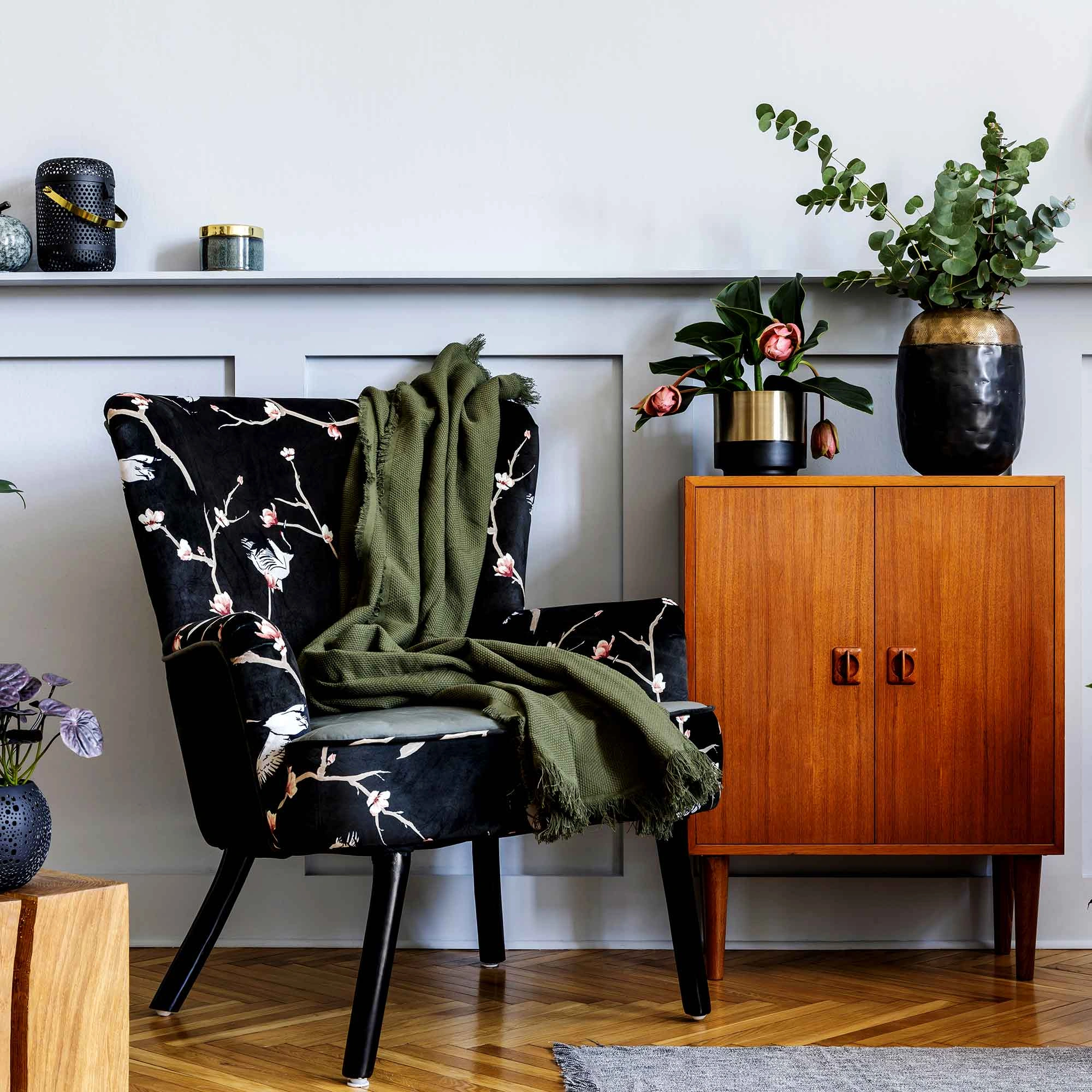 A stylish chair beside a vibrant vase of flowers, showcasing modern furniture interior design in a 3D-rendered image